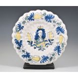 A Dutch Delft polychrome lobed circular dish, late 17th Century with a painted portrait of King