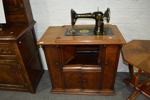Singer treadle sewing machine, in a walnut cabinet case, some losses, width 81cm.
