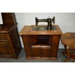 Singer treadle sewing machine, in a walnut cabinet case, some losses, width 81cm.