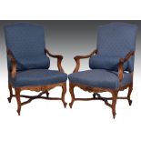 Pair of French carved walnut easy chairs, upholstered in blue pattern brocade, open scrolled arms