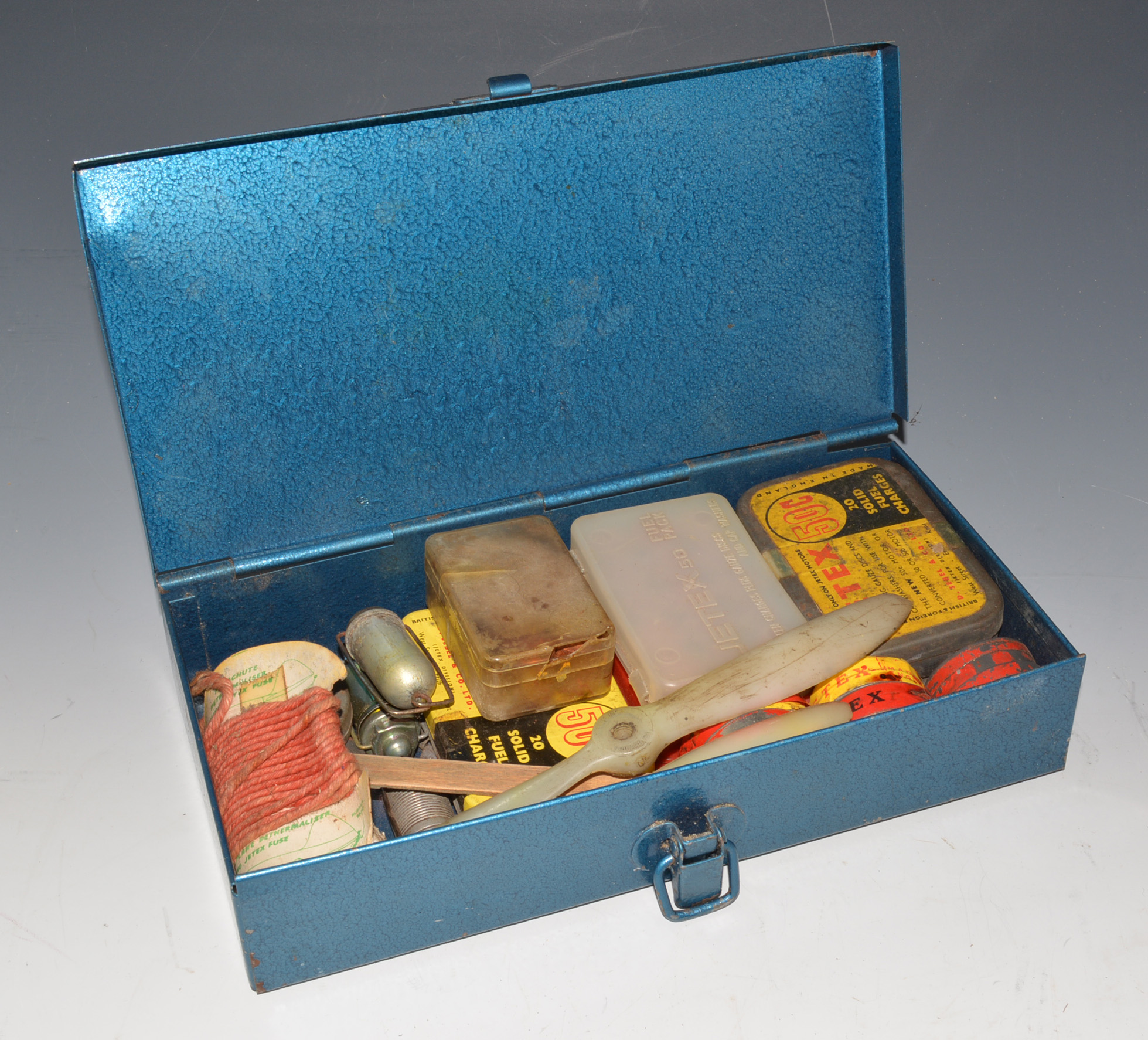 Metal box containing 3 Jetex motors, including fuel pellets and fuses.