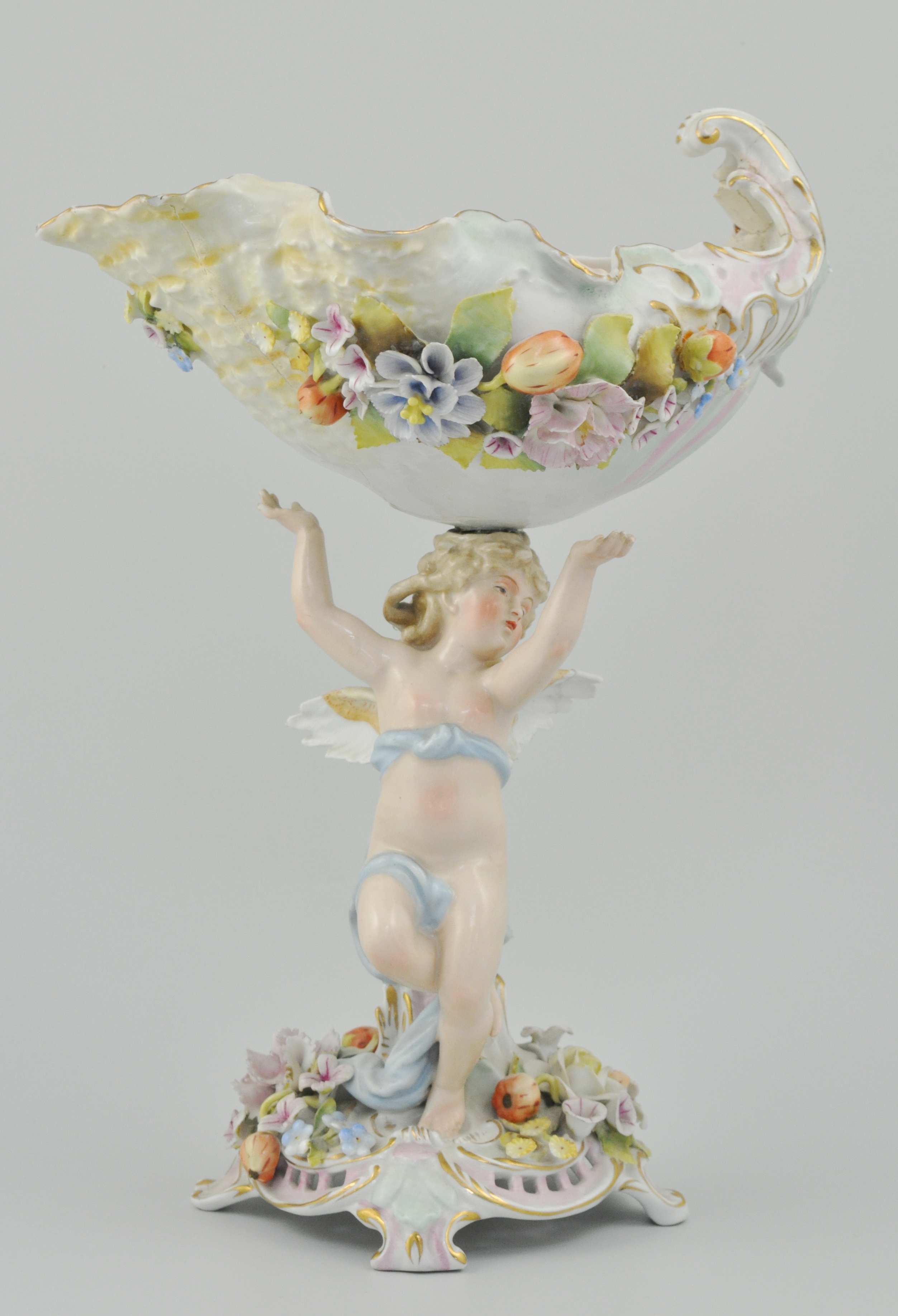 Sitzendorf porcelain comport, a shell mounted bowl supported by a cherub, encrusted decoration,