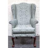 Oak elbow chair, emerald green floral upholstery, raised on cabriole legs.