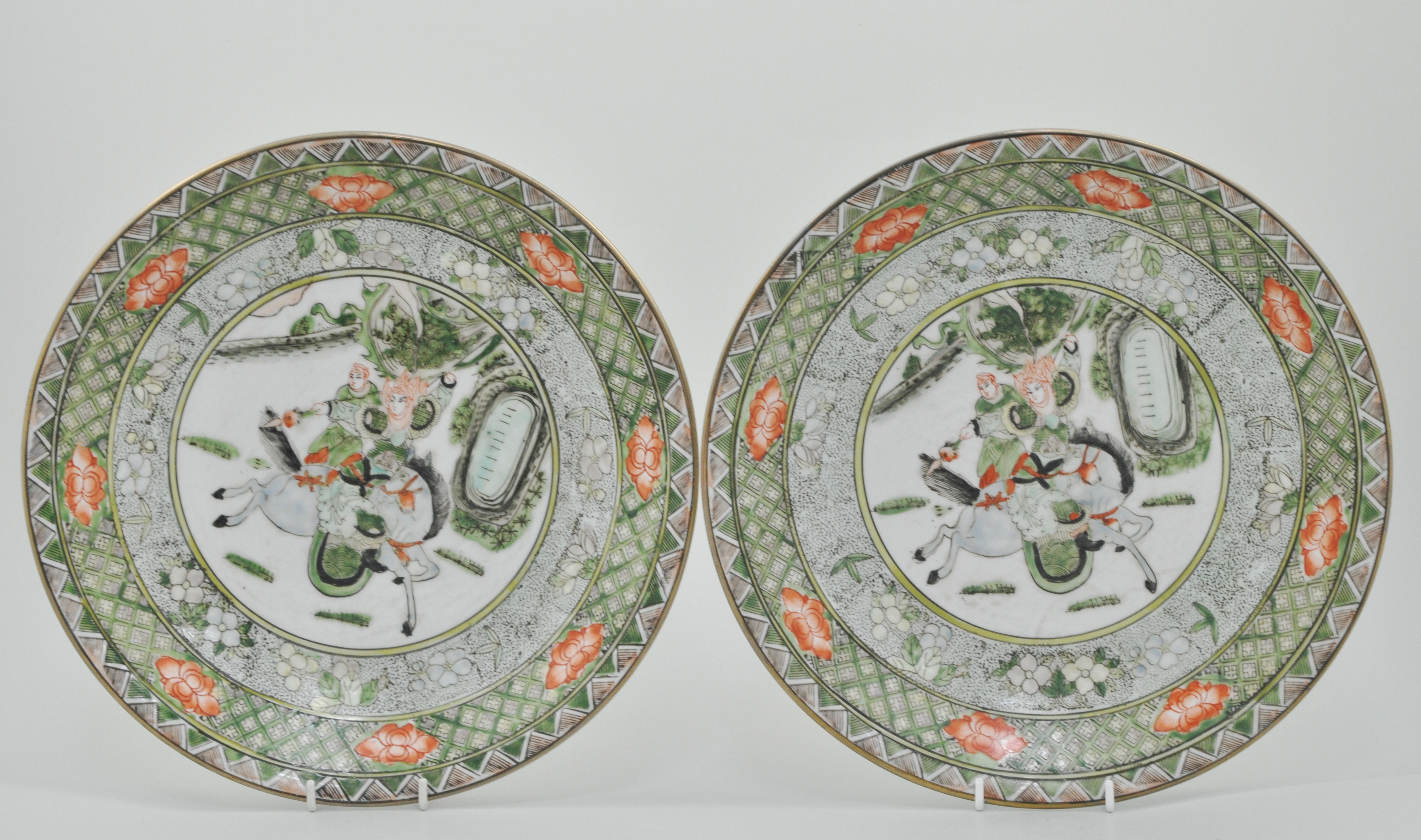 Pair of Chinese Famille Verte chargers, decorated with oriental hunting scenes,