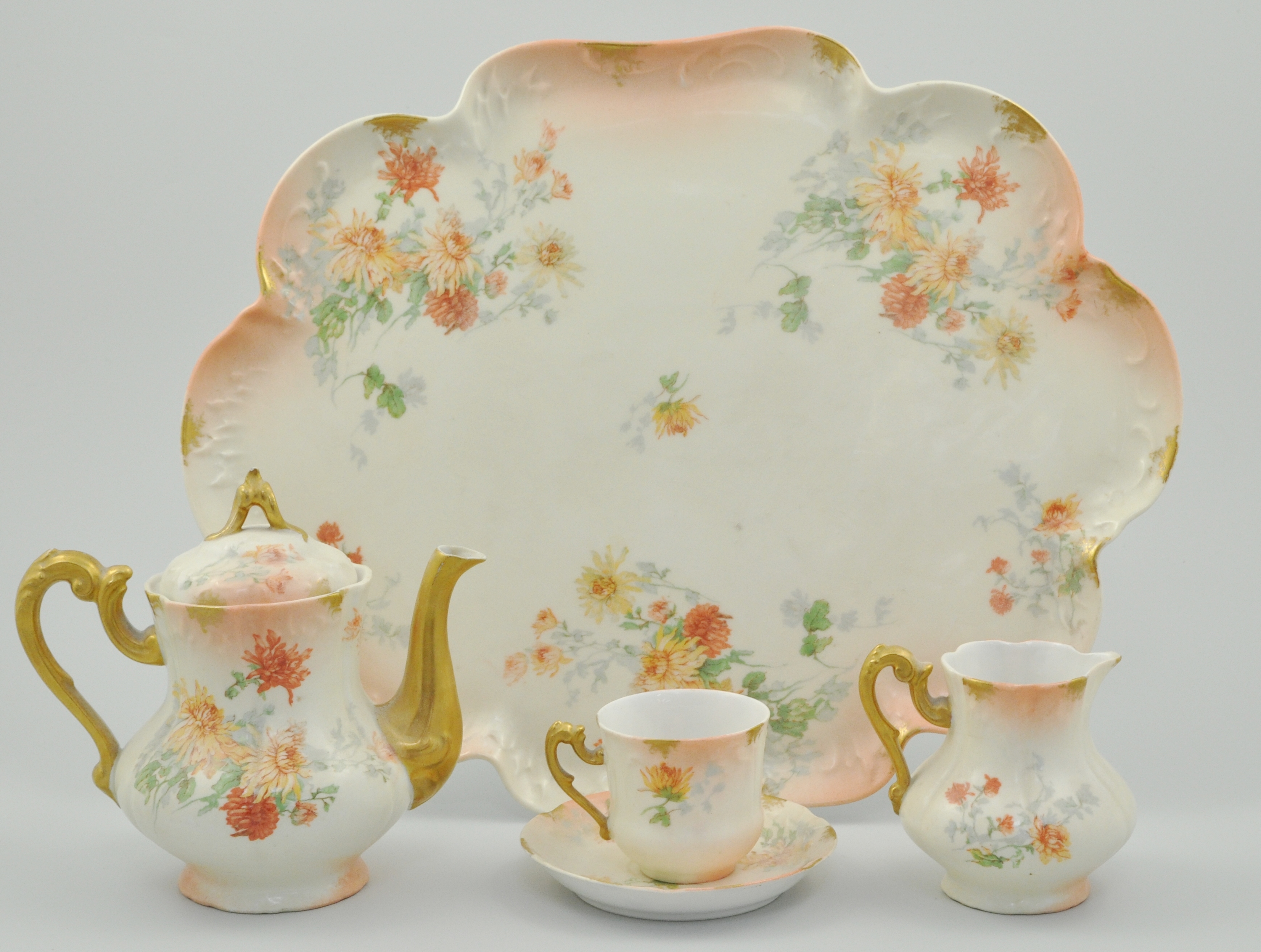 French porcelain part cabaret set, peach and floral decoration, comprising of a teapot, milk jug,