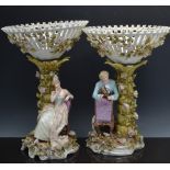 Pair of German porcelain figural comports, circa 1900, pierced conical shape baskets,