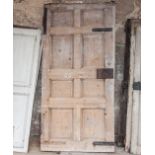 Large stained wood door, with eight fielded panels, 237cm x 114cm and two part upholstered doors,