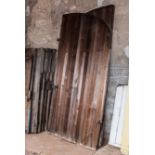 Pair of cedar slatted arched barn doors, with iron fittings, approximately 297cm x 148cm.