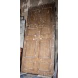 Large stained pine door, with eight fielded panels, 121cm x 273cm.