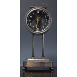 White metal cased mechanical gravity clock, glass dial, visible escapement, 27cms.