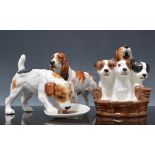 Four Royal Doulton dog models, including Three Terriers in a Basket, HN2588, Dog with Plate, HN1158,