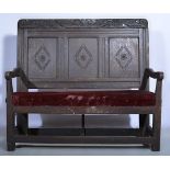 Joined oak settle, carved cresting, three-panelled back, open arms, velvet upholstered seat,