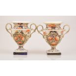 A pair of Derby porcelain campana shaped urns, early 19th Century, each with twin scrolled handles,