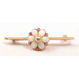 An Edwardian bar brooch, central cluster with six oval cabochon cut opals, spaced by rubies,