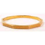 A 15ct hallmarked gold 5.8mm wide ten sided engine turned bangle, Birmingham 1928, 15grms.