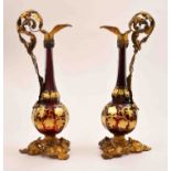 A pair of Victorian ruby glass and gilt metal mounted ornamental ewers,