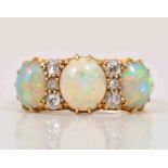 An Edwardian opal and diamond half hoop ring, three oval cabochon cut opals,