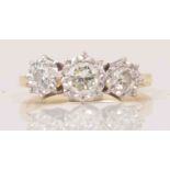 A three-stone diamond ring, brilliant cut stones, illusion set in a yellow and white metal setting,