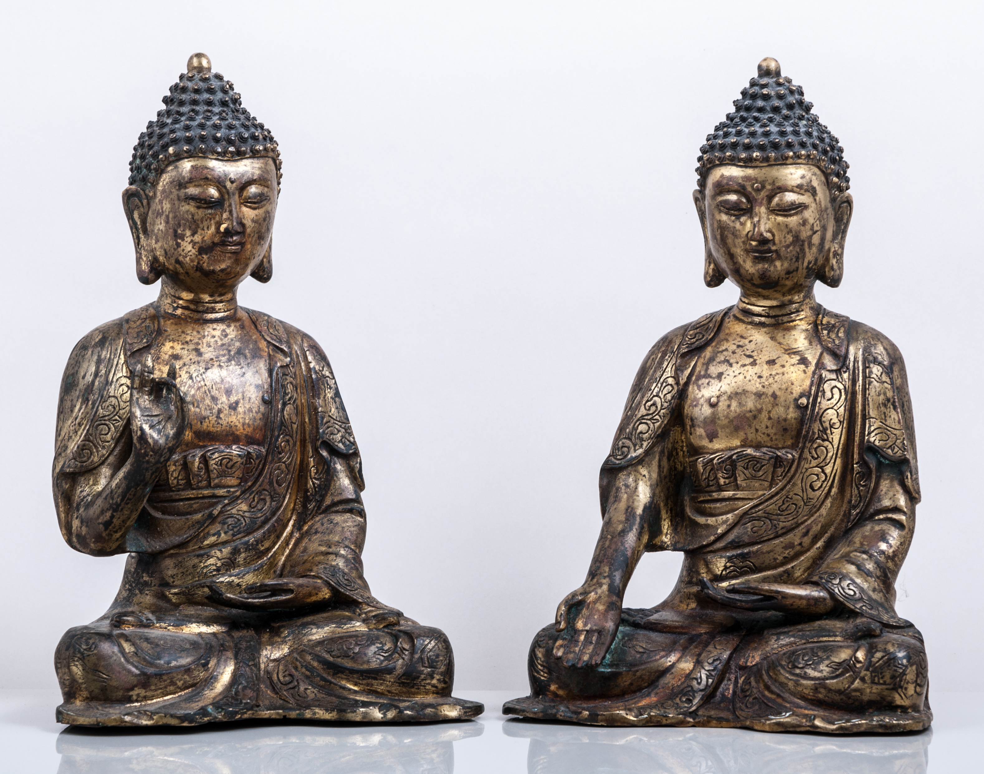 A pair of Sino-Tibetan copper-gilt figures of Buddha, the robes matching, both seated in dhyanasana,