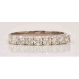 A diamond half eternity ring, white metal mount set with eight brilliant cut diamonds, stamped 18ct.