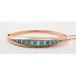 A Victorian rose metal half hinged bangle, set with nine graduating oval cabochon turquoise,