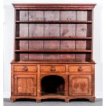 A George III oak dresser, with a matched three shelf delft rack under an ogee moulded cornice,