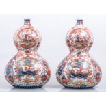 A pair of Imari porcelain double gourd shape vases, probably Meiji, reserves decorated with dragons,