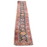 Persian runner, blue ground with floral pattern, red ground stylised border, 570 x 118cms, damaged.