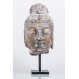 A Chinese stone head, probably Guanyin, perhaps Ming Dynasty, ornamented hair drawn back,