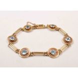 A yellow metal aquamarine set bracelet, the stones in open circular mounts,