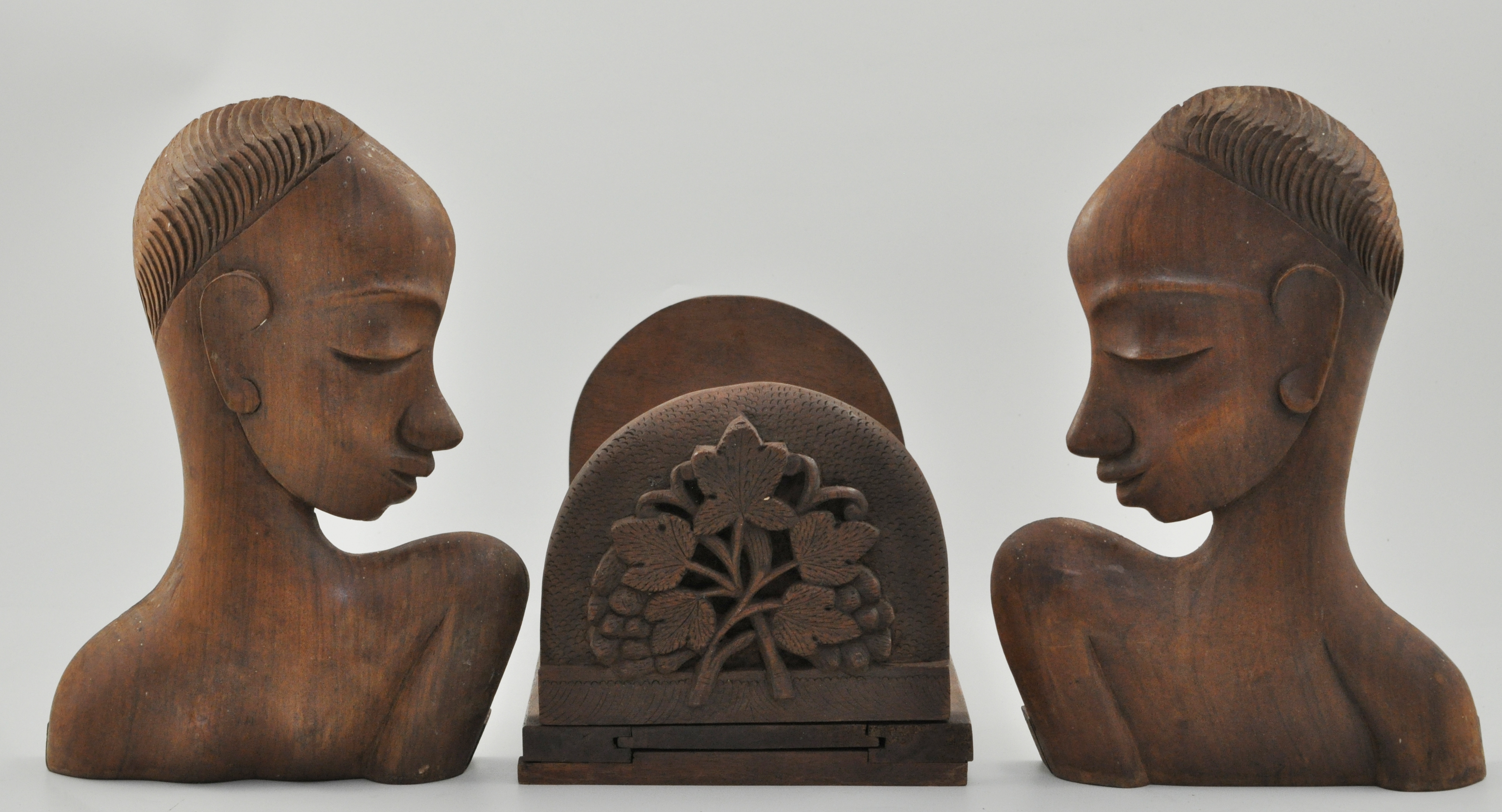 Two carved hardwood extended book racks, two carved wood lamp bases and a pair of busts,