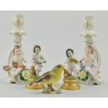 Pair of Sitzendorf candlesticks, decorated with cherubs with flowering encrusted bases,