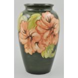 Walter Moorcroft ovoid vase, decorated in the Hibiscus pattern on a green ground, height 22cms.