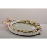 Sitzendorf porcelain oval mirror, encrusted with roses and modelled with two cherubs,