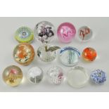 Collection of thirteen glass paperweights.