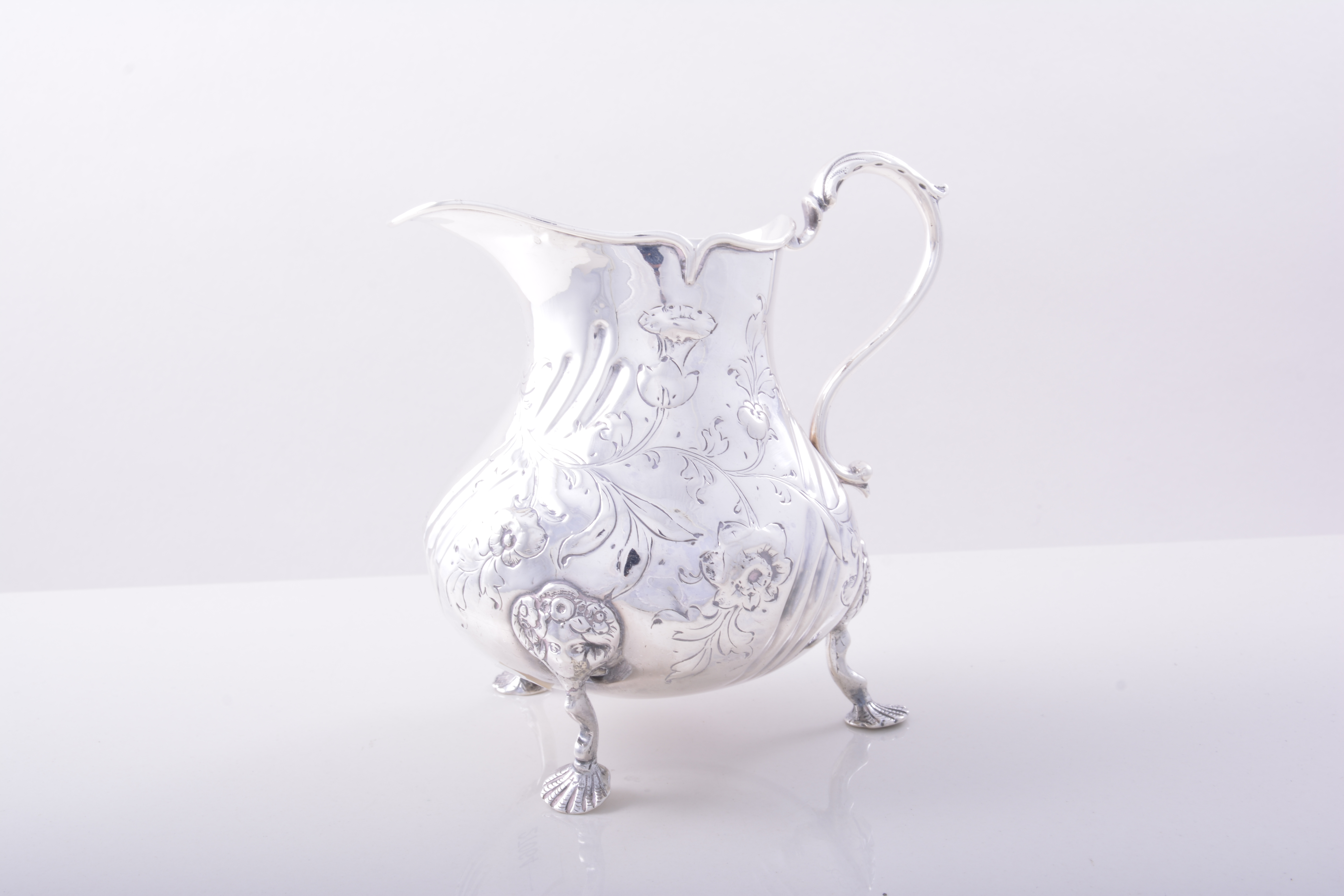 A George III Irish silver pear shaped jug, Dublin circa 1749, wrythen fluted bands,