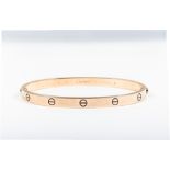 Cartier - An 18 carat yellow gold "Love Bangle" decorated with a number of screw head motifs.