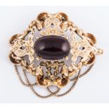 A Victorian yellow metal cast brooch, with oval cabochon cut garnet to centre,