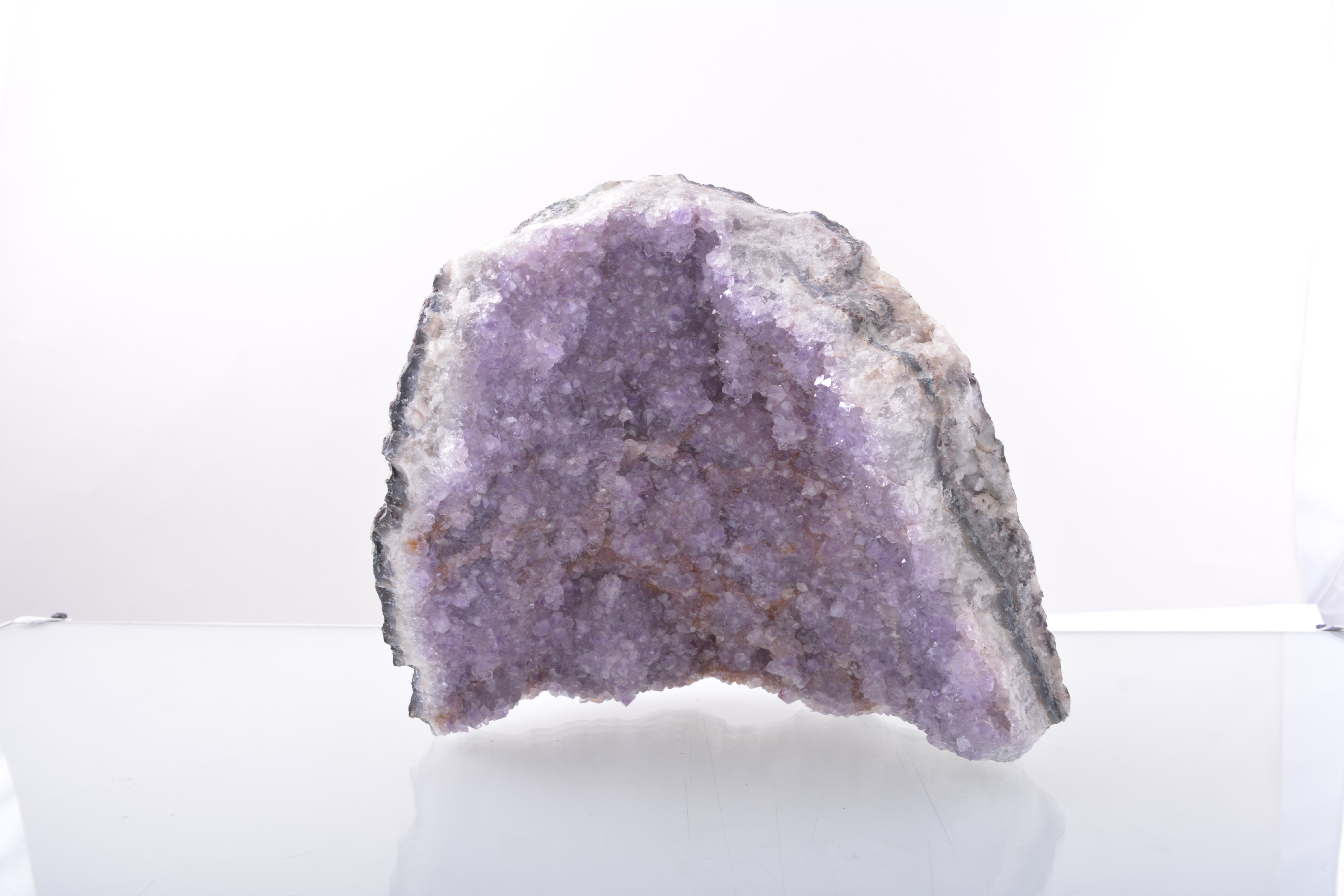 An Amethyst part geode displaying small bright crystals.