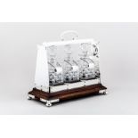 An Edwardian oak and electroplated three bottle tantalus, tapering frame, with a carrying handle,