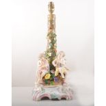 A pair of German porcelain bases, floral encrusted rustic columns,