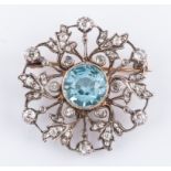 A diamond and aquamarine yellow and white metal circular brooch,