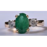 An emerald and diamond traditional three stone ring, the oval mixed cut emerald to centre, 10.