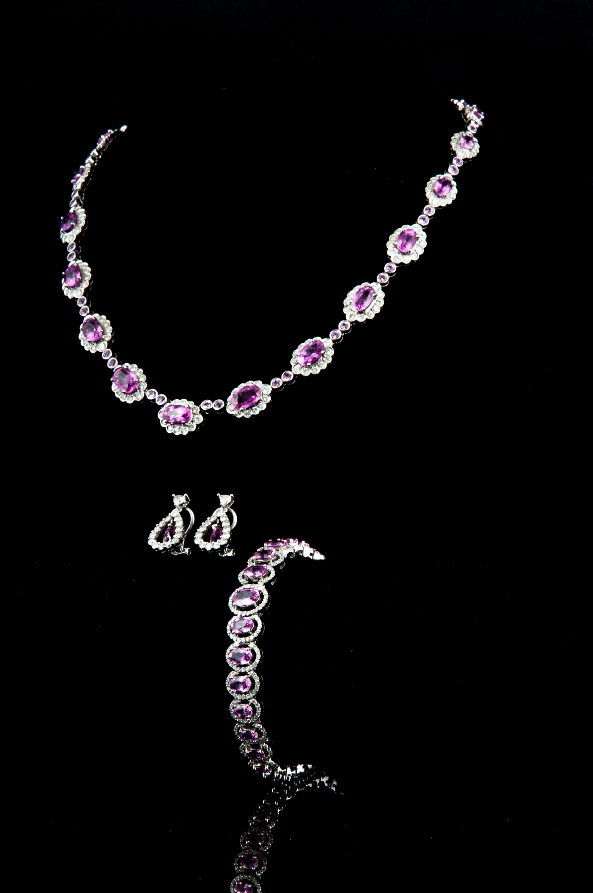A pink sapphire and diamond suite of necklace, bracelet and earrings.