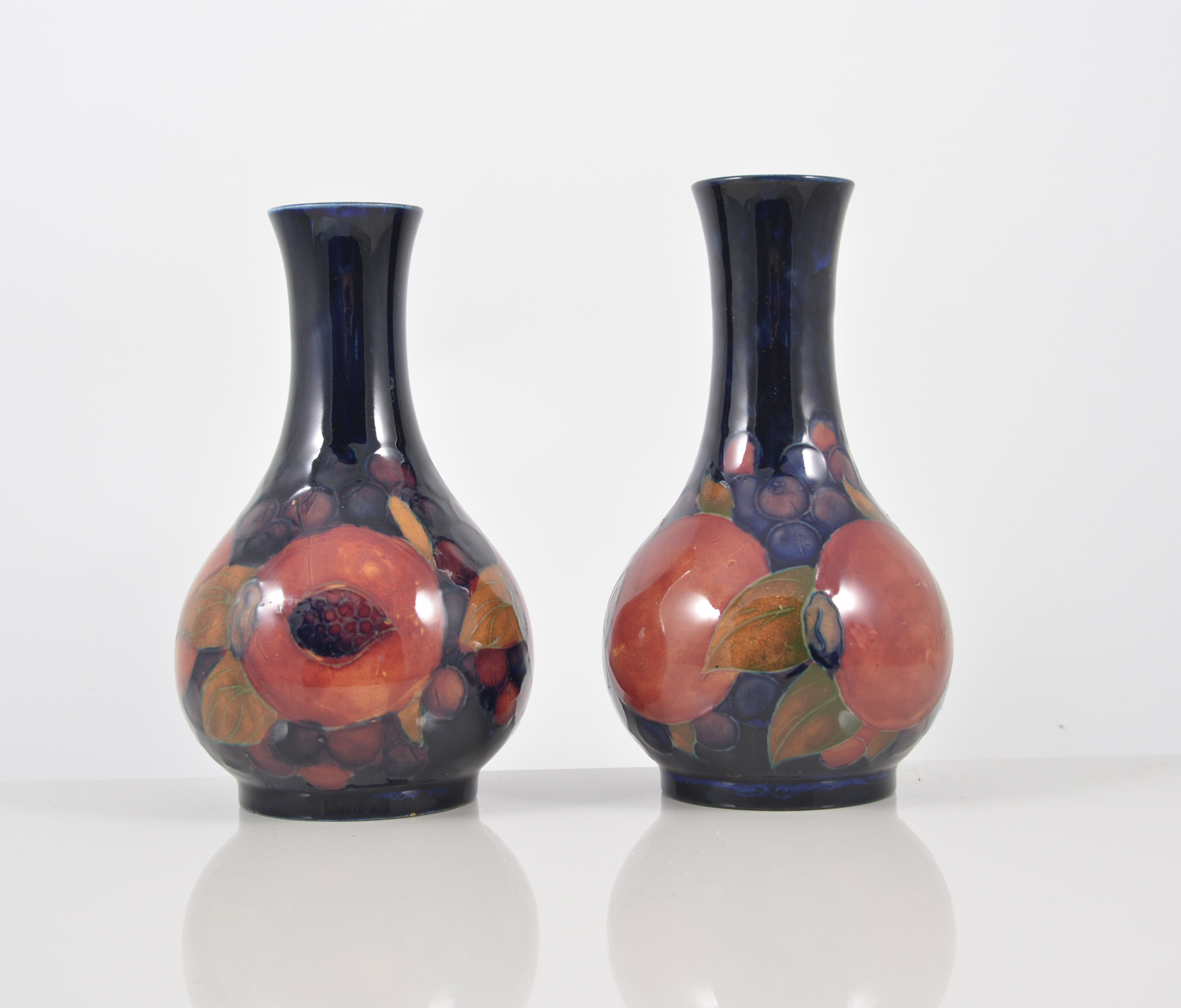 William Moorcroft, a pair of "Pomegranate" vases, circa 1925, stamped factory marks, green initials,