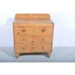 A pine chest of drawers, with arched splash board above two short and two long drawers,