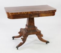 An early 19th century crossbanded mahogany folding card table, the swivel top on a tapering square