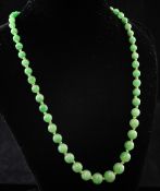 A single strand graduated jadeite bead necklace with old cut diamond set white metal clasp, 17in.