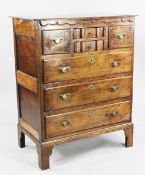 An 18th century oak chest, with two small central shaped drawers between two smaller drawers above