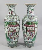 A pair of massive Chinese famille rose baluster vases, each painted to reserves with a procession of